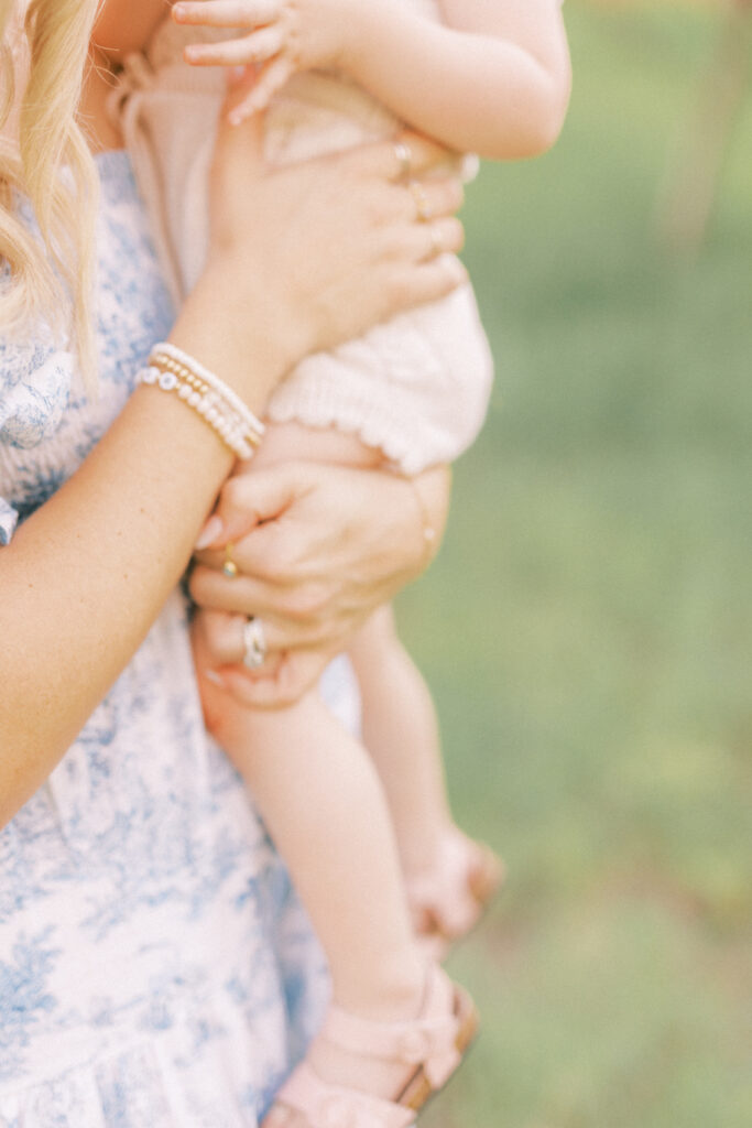 A close up shot of mom in blue dress holding daughter close