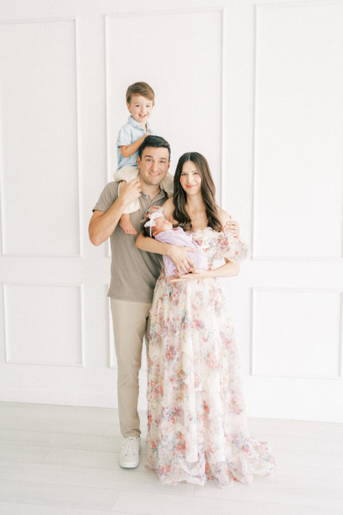 mom holding newborn while dad holds son on his shoulders in a studio in phoenix arizona.