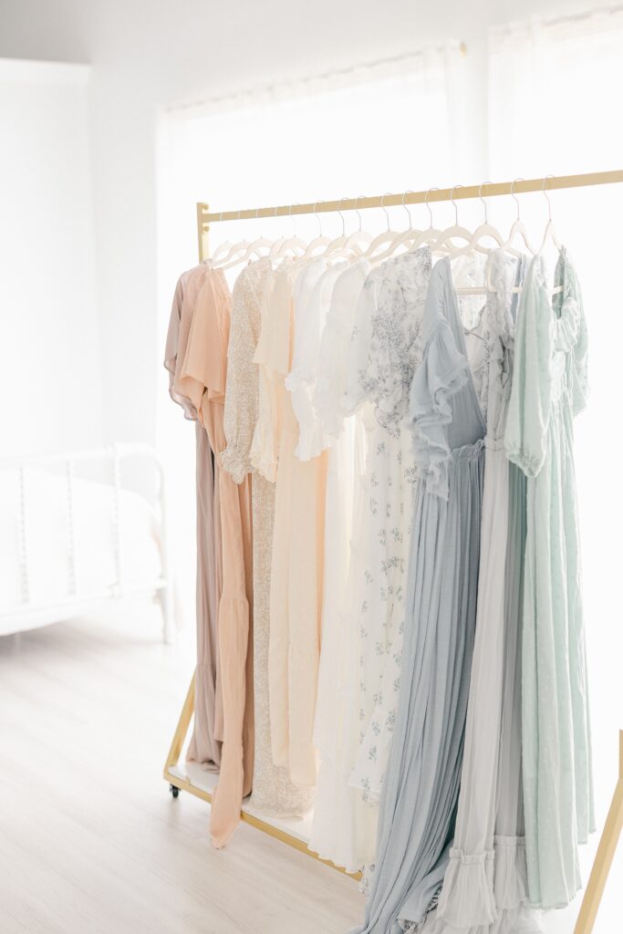 Beautiful gowns hung up on a gold rack at Phoenix studio.