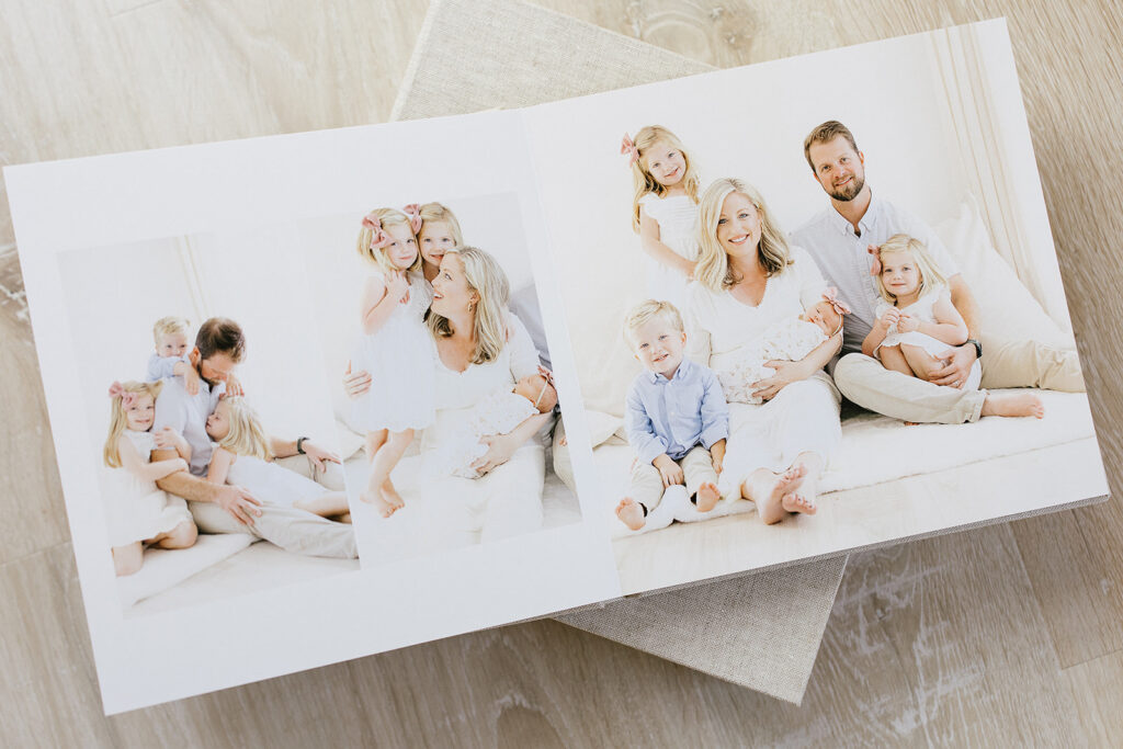 An heirloom album open and showing a newborn session with mom, dad, and three other children.