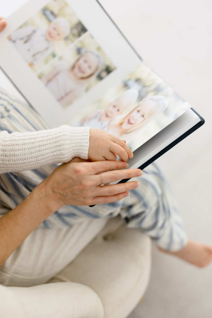 Two people flipping through an heirloom album in scottsdale arizona showing two children.