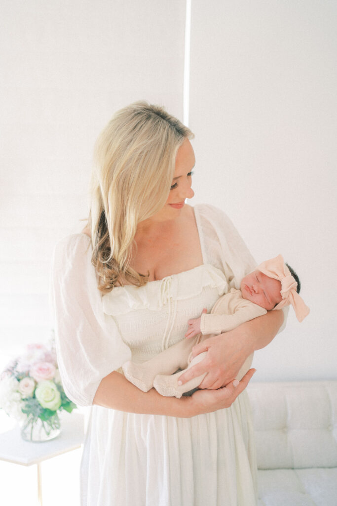 Mom in white dress holding newborn baby in Phoenix Arizona.
