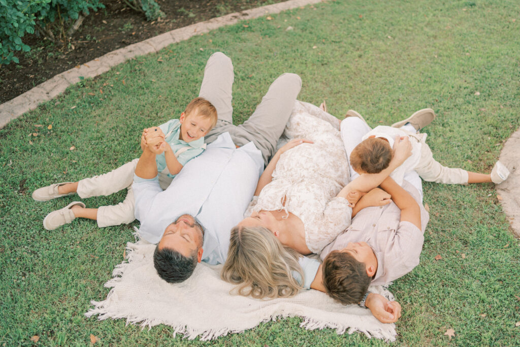 A family laying around their pregnant mom in Mesa Arizona.
